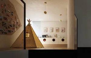 A modern playroom with a tent, cabinets, and decorative elements.