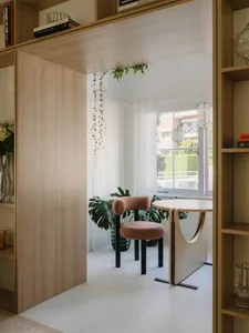 A modern living space with white flooring, wooden furnishings, and glass accents.