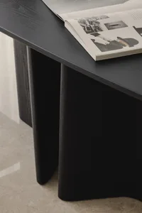 A modern black desk made of wood with a sculpture-like design.