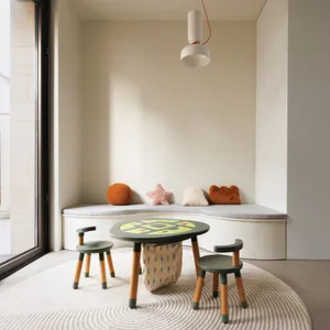 Modern playroom with wooden furniture, including a table and chairs, and a cushioned bench with colorful pillows.