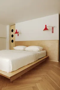 Minimalist bedroom featuring a floating bed supported by wooden walls.