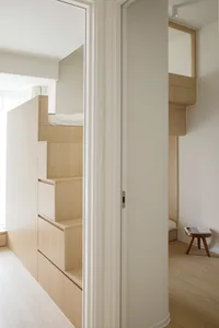 A minimalist bedroom featuring wooden storage units