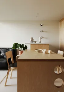 A minimalist kitchen with a wooden countertop and black leather sofa.