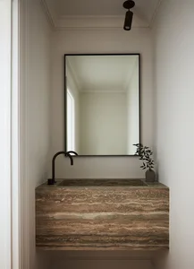 A minimalist bathroom featuring a modern marble counter with a sleek black faucet.