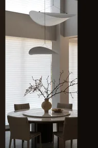 Contemporary dining room featuring modern white marble table and minimalist pendant lights.