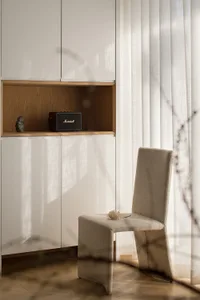 Modern living room with neutral toned furniture, minimalist decor, and wooden floor.