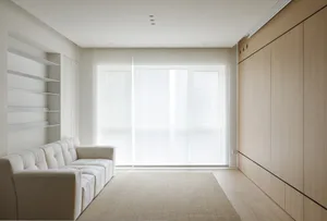 Minimalist living room with white furniture and wooden walls.