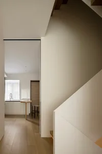 Wooden staircase adjacent to a modern kitchen
