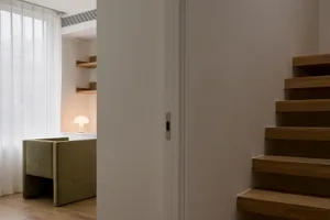 Modern staircase with wooden steps in a contemporary white interior setting.