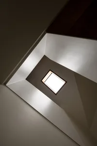 A bright, modern staircase with a skylight at the top.