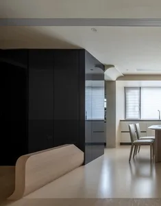 Modern kitchen with black glass cabinets, white marble countertops, and concrete flooring.