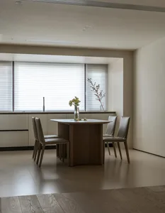 A modern kitchen featuring wooden cabinetry and a dining table with chairs.