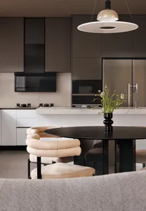 Modern minimalist kitchen with a round black table, beige chairs, and natural lighting from above.