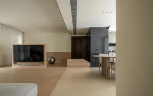 A modern minimalist living room with a wooden floor, white walls, and a television stand.