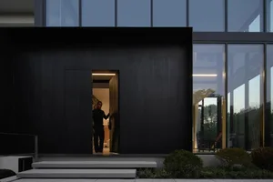 A modern house with concrete walls and black-framed windows.