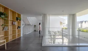 Modern residential entryway featuring glass walls and a concrete floor.