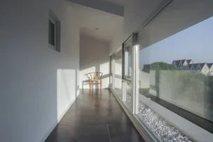 極簡住宅室內，配有大型玻璃窗，可眺望綠意景色。