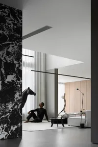 A modern living room with marble walls and concrete flooring.