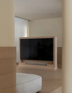 A modern living room featuring a wooden TV stand and floor-to-ceiling windows with white curtains.