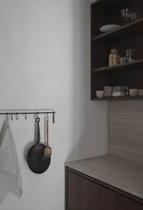 Modern minimalist kitchen featuring concrete countertops and wooden cabinets.