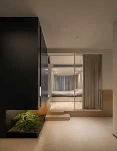 A minimalist interior with wooden flooring, glass partitions, and concrete surfaces.