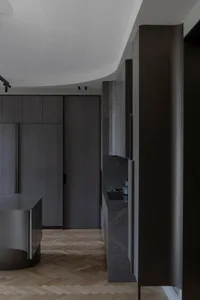 Modern kitchen with dark marble countertops and cabinets.
