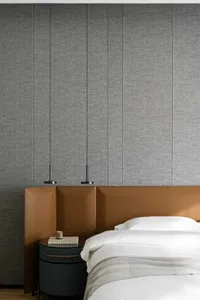 Modern minimalist bedroom interior with taupe acoustic panels, white bedding, and round nightstand.