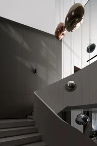 Modern staircase with metallic railing and wall lighting.