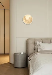 A minimalist bedroom with a circular light fixture illuminating the scene.
