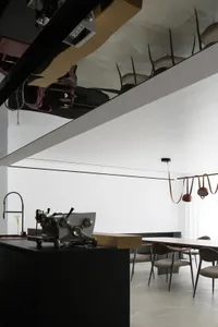 Modern kitchen and dining space featuring metallic black cabinetry, wood accents, and minimalist design.