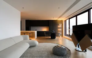 Modern living room featuring black and white furniture, a large window, and contemporary decor.