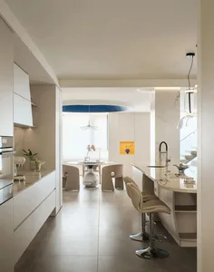 Modern minimalist kitchen featuring marble countertops, wooden cabinets, and stainless steel appliances.
