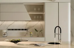 Modern kitchen with marble countertops, white cabinets, and a sink with a black faucet and chrome accents.