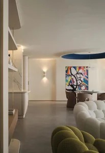 A modern living room with neutral-toned furniture and a colorful abstract painting on the wall.