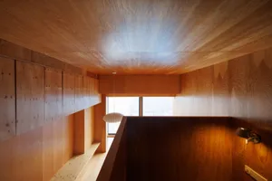 A modern wooden interior with a skylight and a contemporary light fixture.