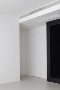 A minimalist interior with white walls and a concrete floor.