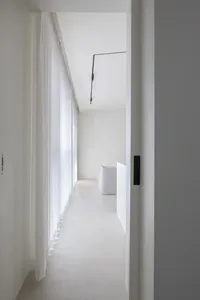 A minimalist interior space with white walls, glass walls, and a sleek, modern design.
