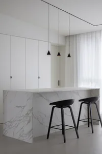 A modern kitchen with marble countertops and minimalist design.