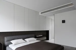 Minimalist bedroom with gray furniture and white bedding.
