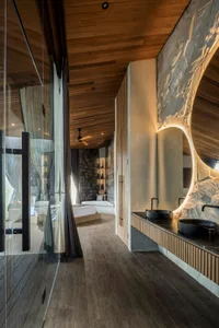 A modern bathroom featuring marble elements and a wooden ceiling.
