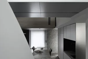 Modern, minimalist kitchen with marble countertops and wooden cabinets.