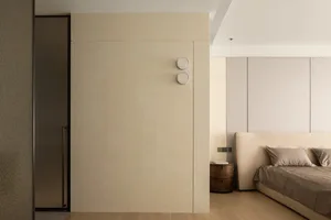 Neutral-toned minimalist bedroom featuring a large bed, side table, and minimalist wall panels.