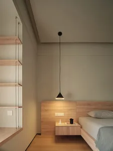 A minimalist bedroom with a wooden bed, floating nightstand, and floating shelves.