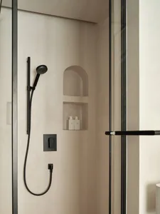 Modern bathroom shower featuring concrete and black metal materials.