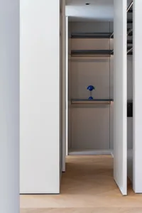 A modern, minimalistic closet with glass shelves.