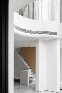Modern minimalist interior with a white abstract sculpture on a polished floor.