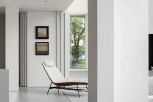 Modern interior featuring a white space with a concrete floor and marble furniture.