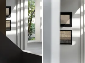 A modern interior scene featuring a window with a wooden frame showcasing abstract art pieces on the walls.