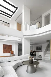 Modern living room with concrete and glass materials and white color scheme