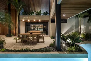 A modern residential interior featuring tropical plants in a wood and concrete setting.